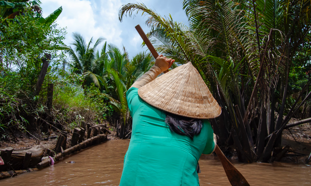 Vietnamese woman travels down Mekong River. 