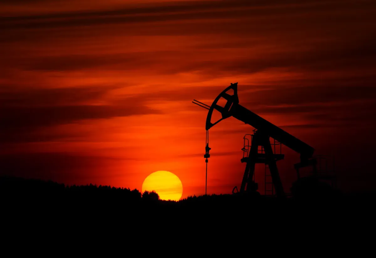 Pump-jack mining crude oil with the sunset.